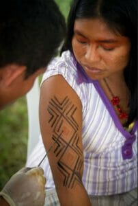 Kaxinawa woman getting kene applied on her arm 